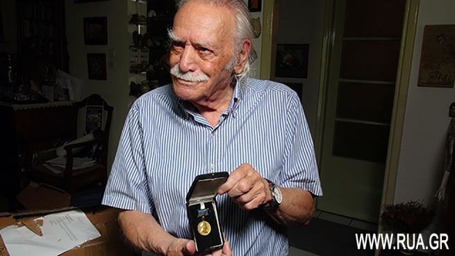 Манолис Глезос показывает знак  лауреата Лениской премии мира. 